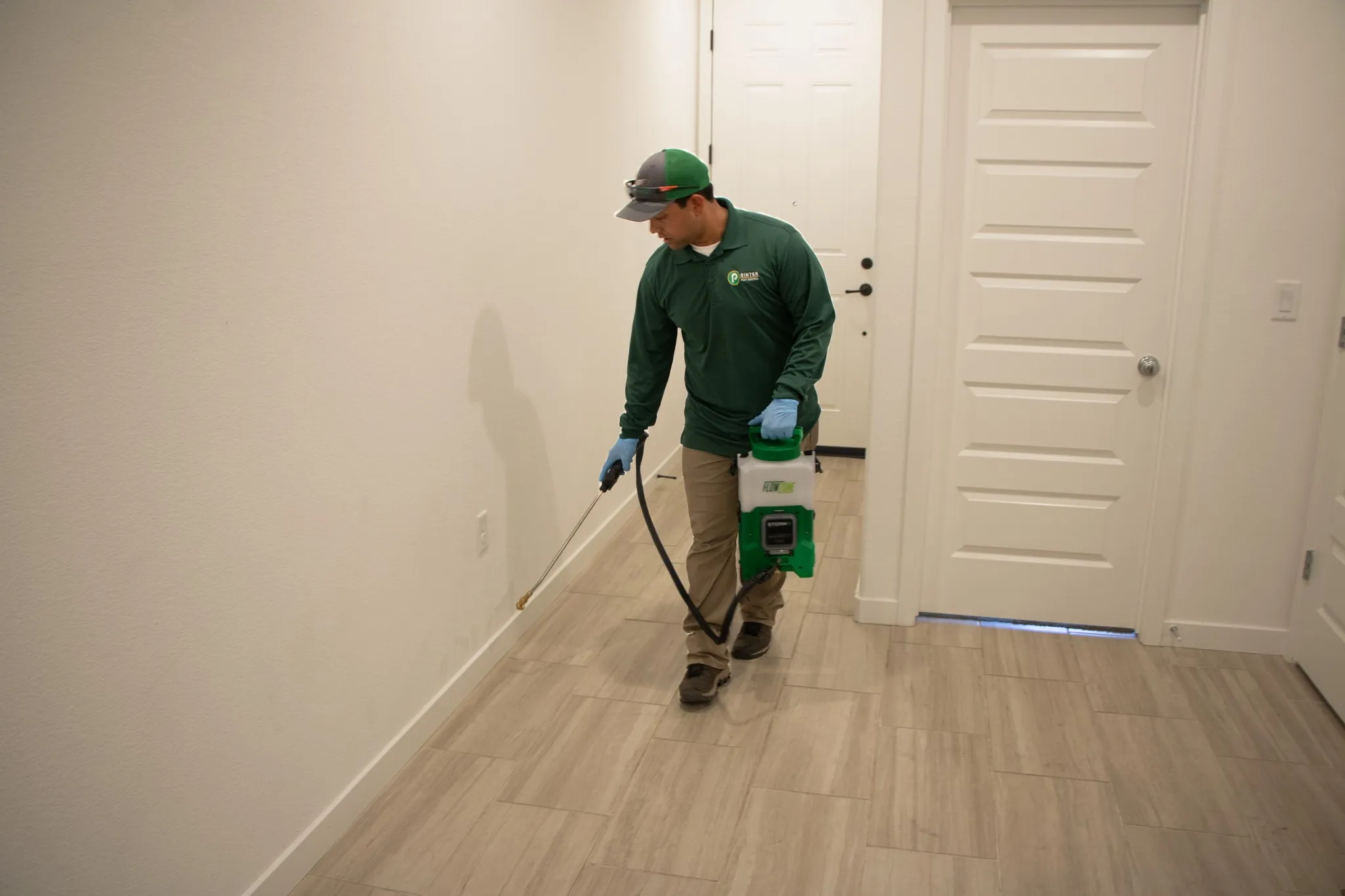 Pointer Pest Control technician treating interior baseboards for ants inside a Granite Bay CA home