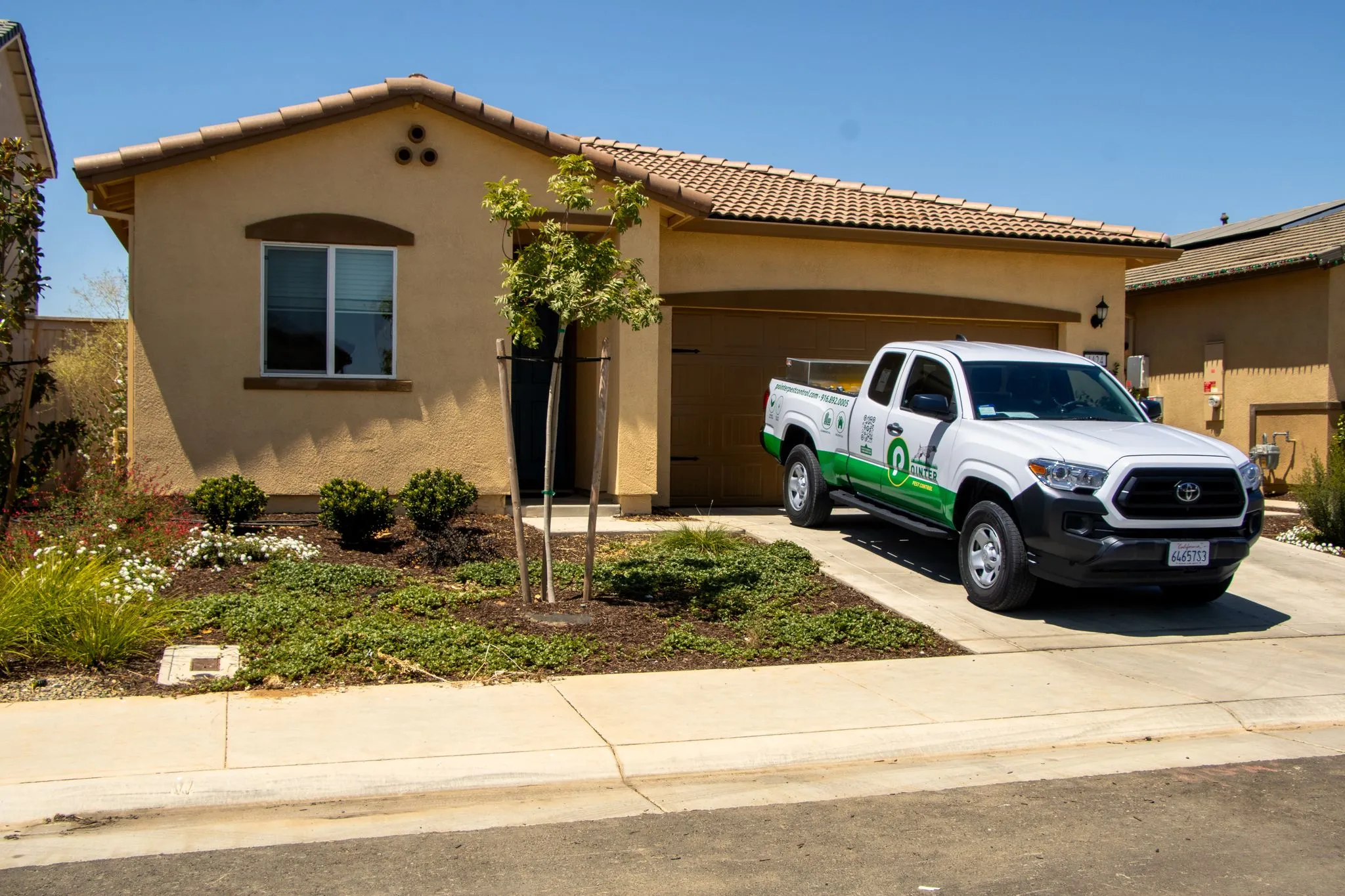 A Pointer Pest Control service truck parked in the driveway of a Roseville CA home